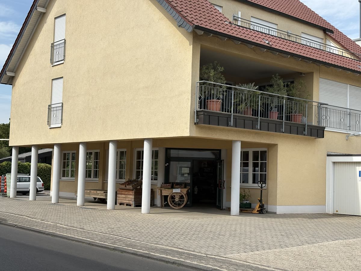 Der zweite Hofladen an der Bonnerstraße 26: ein gelbes Gebäude mit offenem Ladeneingang unter der Arkade